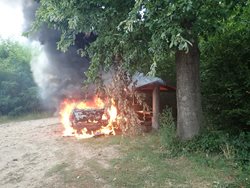 Požár přeskočil z hořícího osobního automobilu na dřevěný přístřešek
