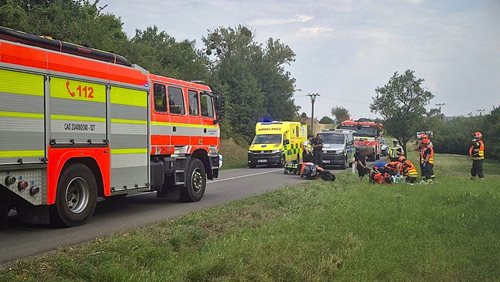 Nehoda motocyklu uzavřela silnici. Zraněnému řidiči jako první pomáhali hasiči