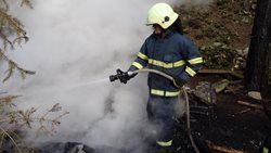 Požár trampského přístřešku v těžko přístupném lesním terénu