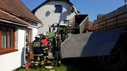 Traktor s přívěsem zbořil plot, část rodinných domů a pergolu