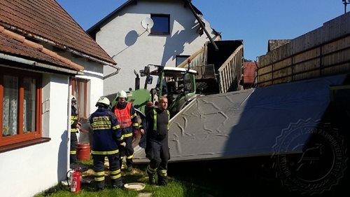 Traktor s přívěsem zbořil plot, část rodinných domů a pergolu