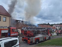 Střecha v plamenech, škoda za miliony a zraněný hasič