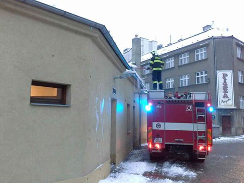 Hasiči pomáhají s odstraňováním padajícího sněhu ze střech.