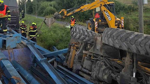 Kamion vezl bagr a ocelové nosníky. Po havárii skončil náklad mimo návěs