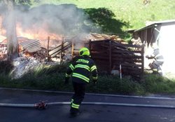 U rodinného domu hořela hromada dřeva