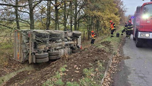 Nákladní vůz se převrátil na bok mimo silnici. Hasiči zasahovali proti úniku kapalin