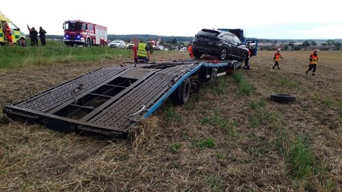 Nákladní automobil převážející čtyři osobní vozidla skončil v poli