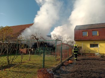 Požár střechy hospodářského objektu ohrožoval okolní domy