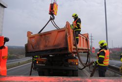 Ostravští hasiči zasouvali u dálnice nakloněnou korbu s asfaltem zpět na auto