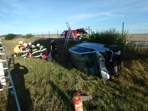 Po nehodě skončil osobní vůz mimo dálnici na boku