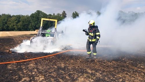 Hořící nakladač zapálil pole i balíky slámy. Hasiči zabránili šíření požáru k lesu