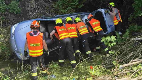Řidička skončila s autem na boku v potoce. Hasiči ji vyprostili přes čelní sklo