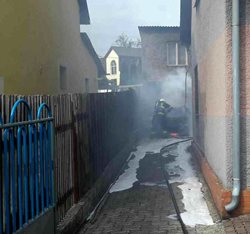 Auto začalo hořet na zahradě mezi domy