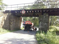 Nákladní vozidlo s naloženým bagrem se zaseklo pod mostem 