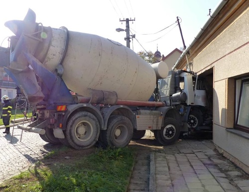 Po nehodě osobního a nákladního auta bylo nutné zajistit poškozený dům