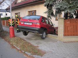 Osobní automobil vyjel z cesty a zůstal viset na plotě.
