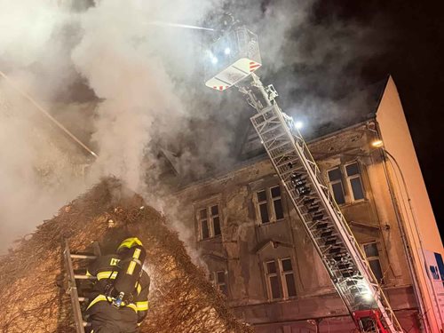 Požár střechy domu ohrozil okolní byty a vyžádal si evakuaci osob