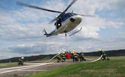 Policejní vrtulník provedl několik shozů vody na travnatou plochu letiště