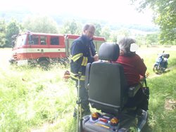  Žena zůstala uvězněna pod převráceným elektrickým invalidním vozíkem.