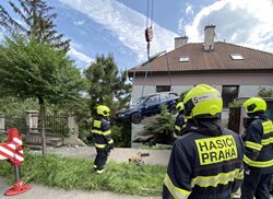 Auto, které sjelo ze silnice do domu v Praze 5, vyprostili hasiči jeřábem