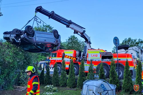 Osobní automobil v noci skončil na střeše v zahradě rodinného domu