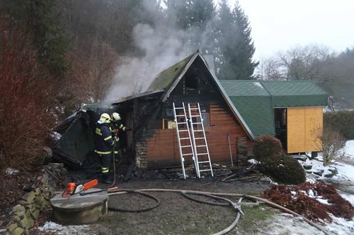 Požár chaty zasáhl garáž a střechu, zasahující osoby musely překonat náročný přístup