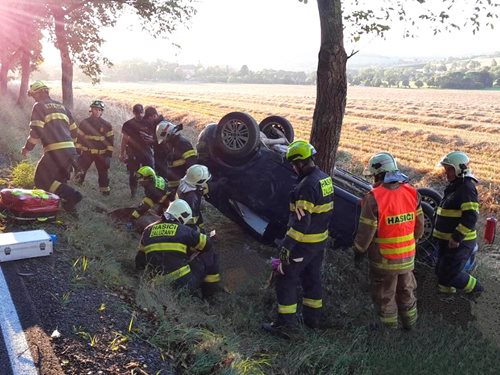 Auto po smyku skončilo na střeše a narazilo do stromu: dva zranění