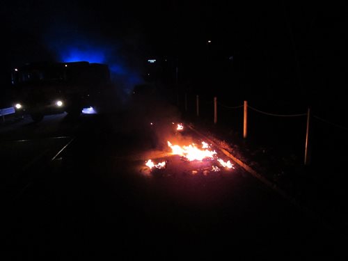 Hasiči zabránili v pohybu hořícího osobního vozu zátarasem zásahovým automobilem. 